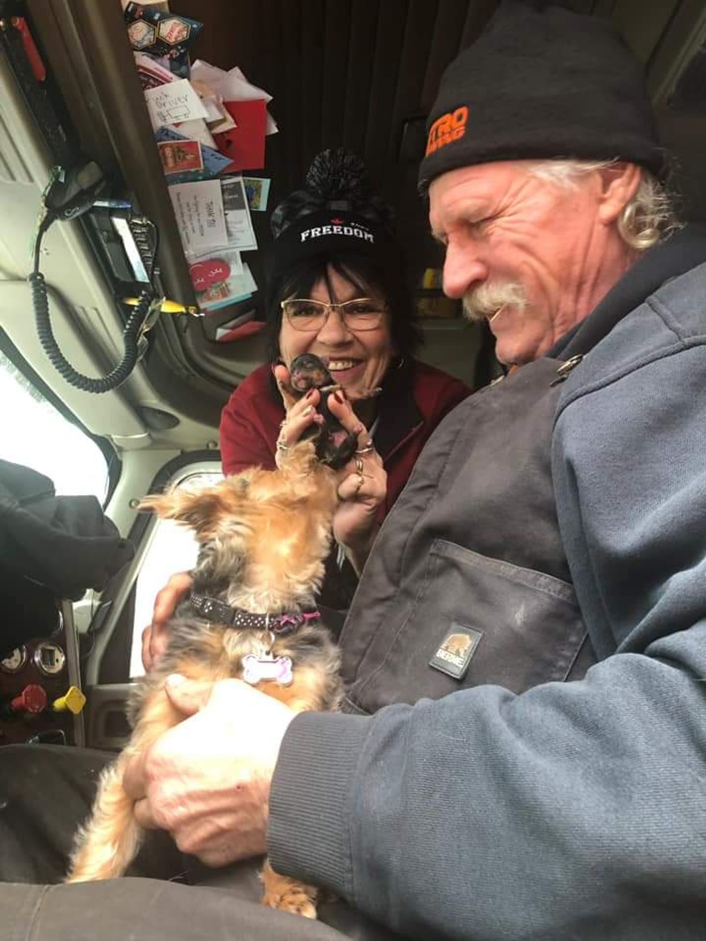 Image of Jake and Lynette Klassen with their Yorkie in the cab of the truck.